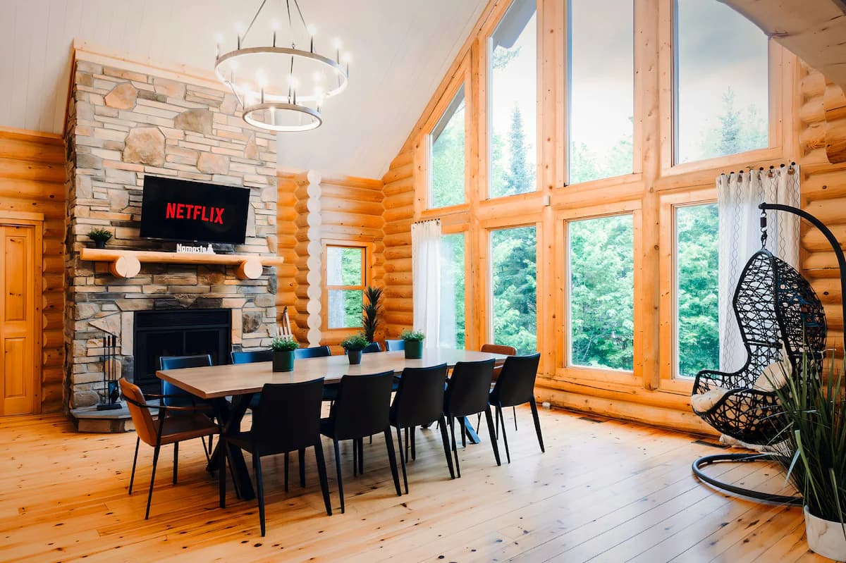 Grande salle à manger lumineuse avec plafond cathédral et foyer au bois