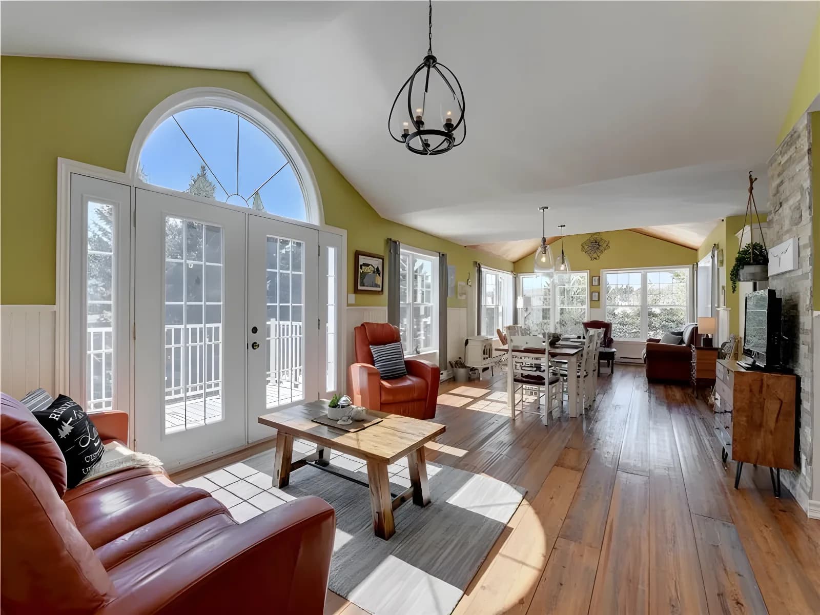 Large, bright chalet located on the waterfront of a lake.